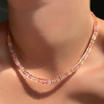 A blush sapphire necklace on a model's neck.