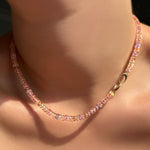 Multi blush padparadscha sapphire necklace on a model's neck with the 14k yellow gold clasp turned towards the front.