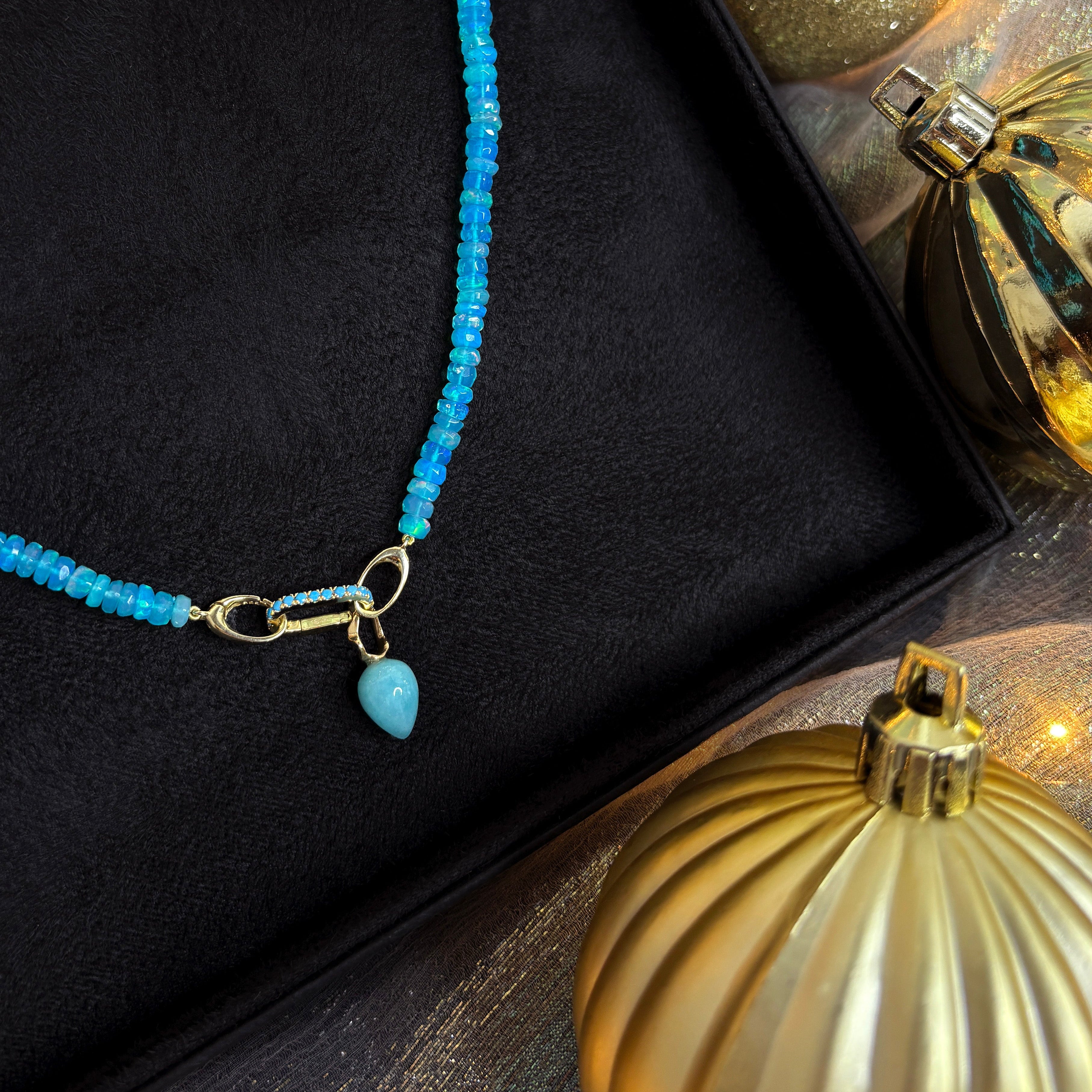 Bright blue faceted opal necklace bundle ready for holiday gifting with christmas lights and gold ornaments.