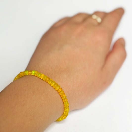 Shimmering beaded bracelet made of smooth opals in shades of yellow on a gold linking lobster clasp.