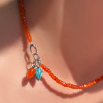 Faceted carnelian necklace with carnelian and turquoise drop charm in the linking ovals clasp.
