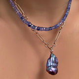 denim blue faceted sapphire necklace layered over an irregular cable chain necklace with blue baroque pearl on 14k yellow gold ripple bale on a model's neck.