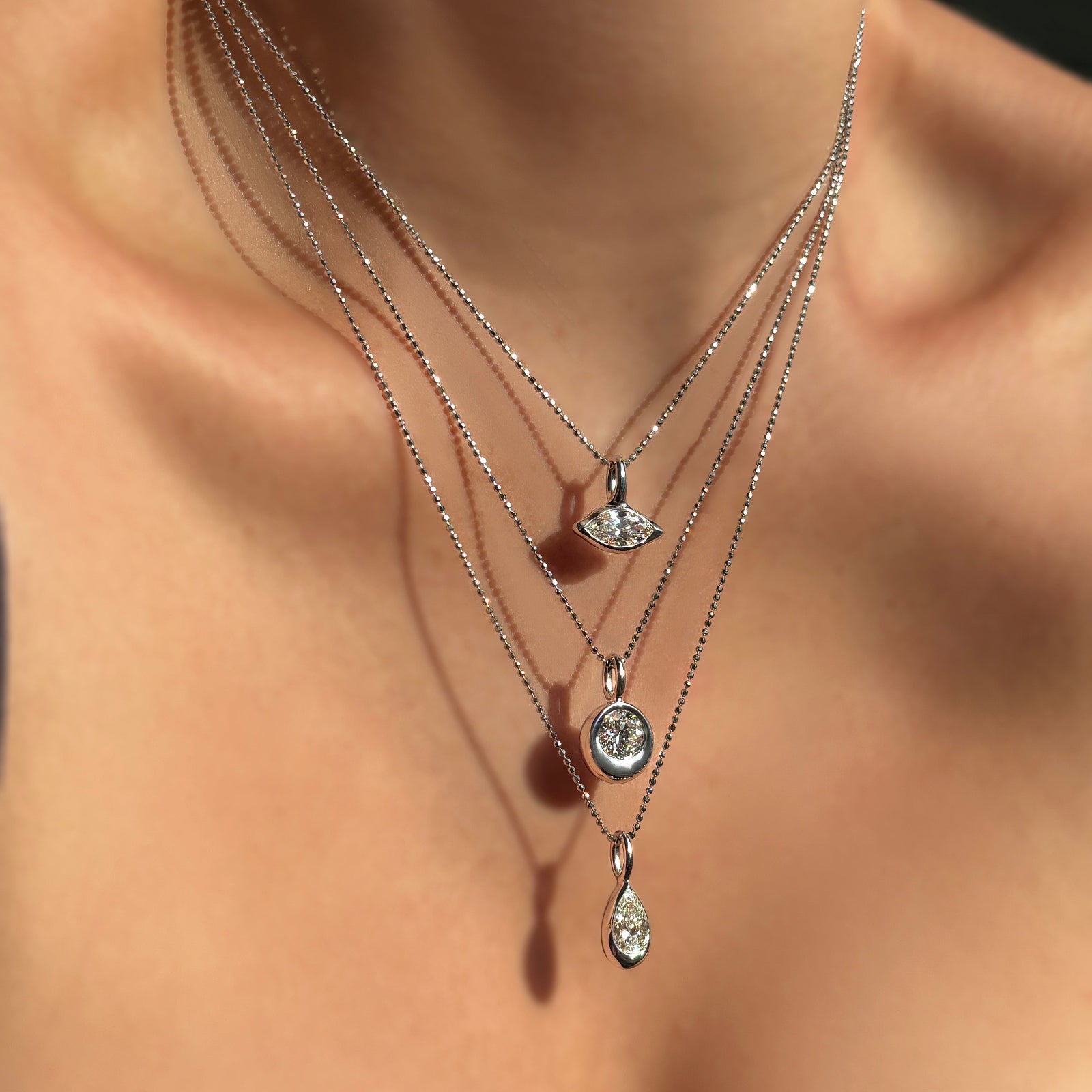 Molten Solitaire Charms with marquise, round, and pear shaped diamonds on diamond cut bead chains.