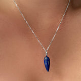 diamond cut cable chain with lapis drop charm on the neck.