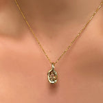 Diamond cut bead chain with knot charm with grey/brown/green tourmaline on a model's neck.