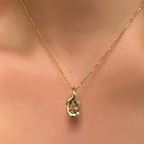 Diamond cut bead chain with knot charm with grey/brown/green tourmaline on a model's neck.