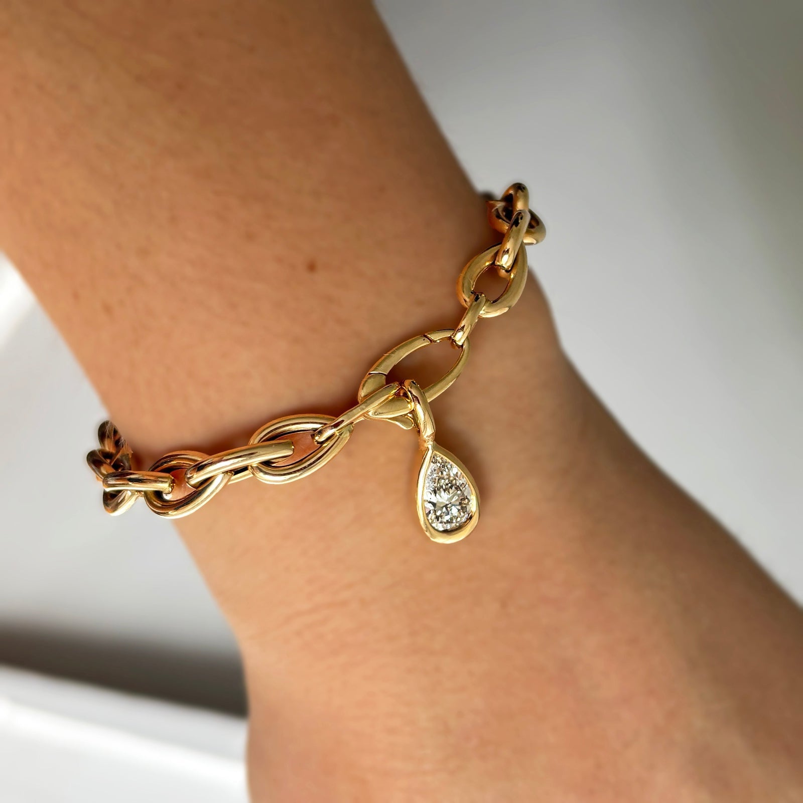 AMANDA PEARL Drop Link chain bracelet with molten solitaire charm with pear diamond in recycled 14k yellow gold.