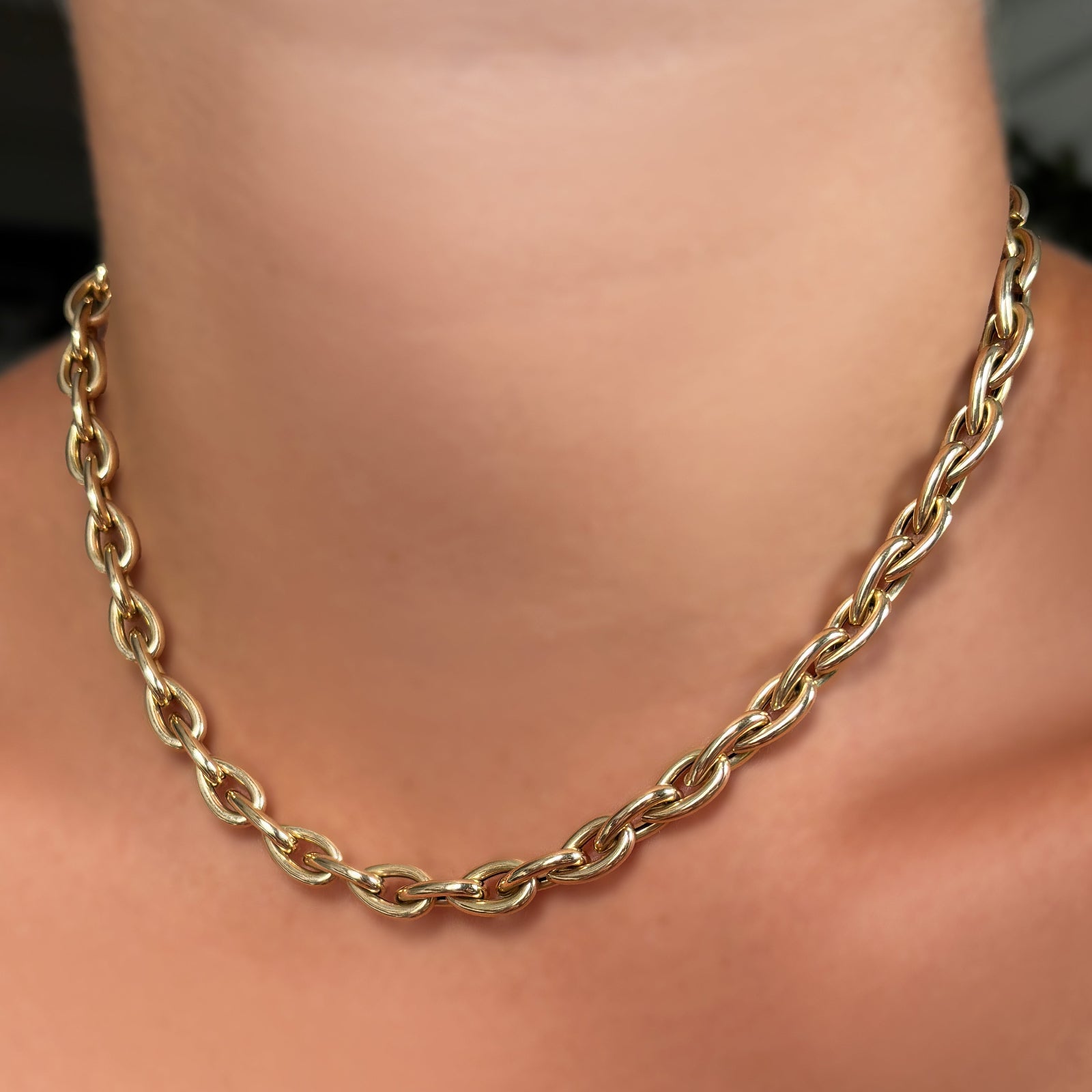 drop link gold chain necklace on a person's neck