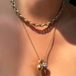 Drop link chain necklace layered over 2mm bead chain necklace in yellow gold with Molten Drop Charm and Molten Solitaire Charm with round diamond, worn on the neck.