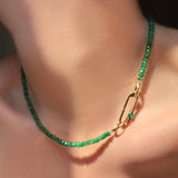 Faceted Emerald Necklace with Paperclip Charm lock with green onyx cabochon on a model's neck.