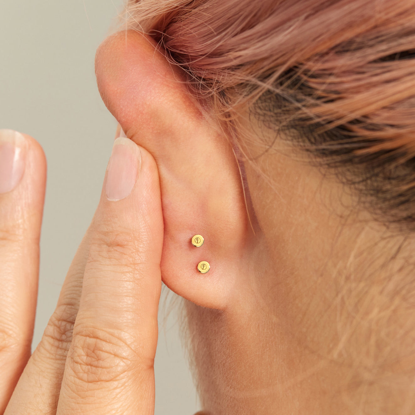 A model shows the flat backs on her ear featuring the AP logo.