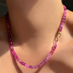 fuchsia faceted sapphire necklace with linking ovals clasp in 14k yellow gold facing front on a model's neck.