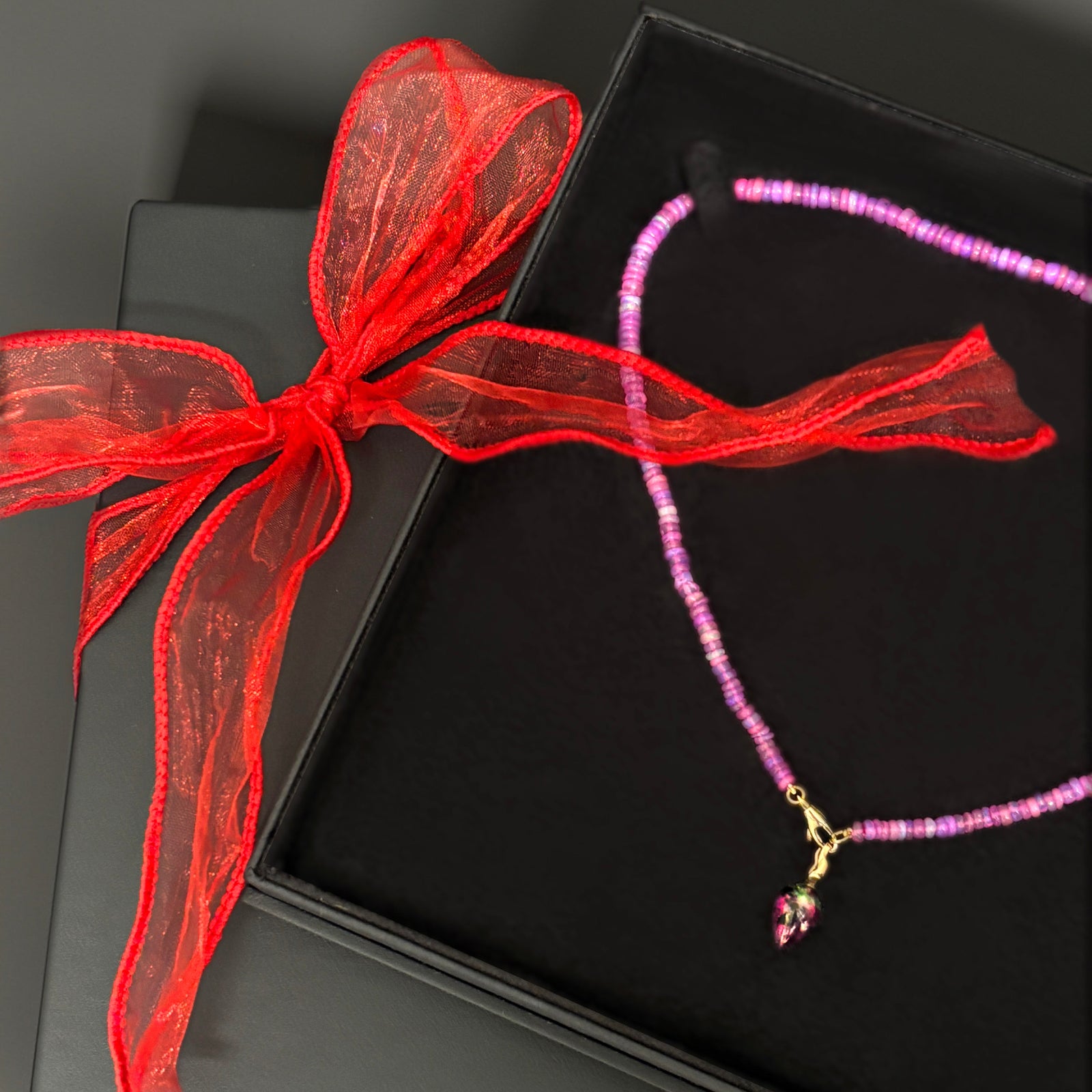 Necklace with a red bow on a black box