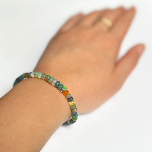 Shimmering beaded bracelet made of faceted opals in shades of green, orange, yellow on a gold linking lobster clasp.