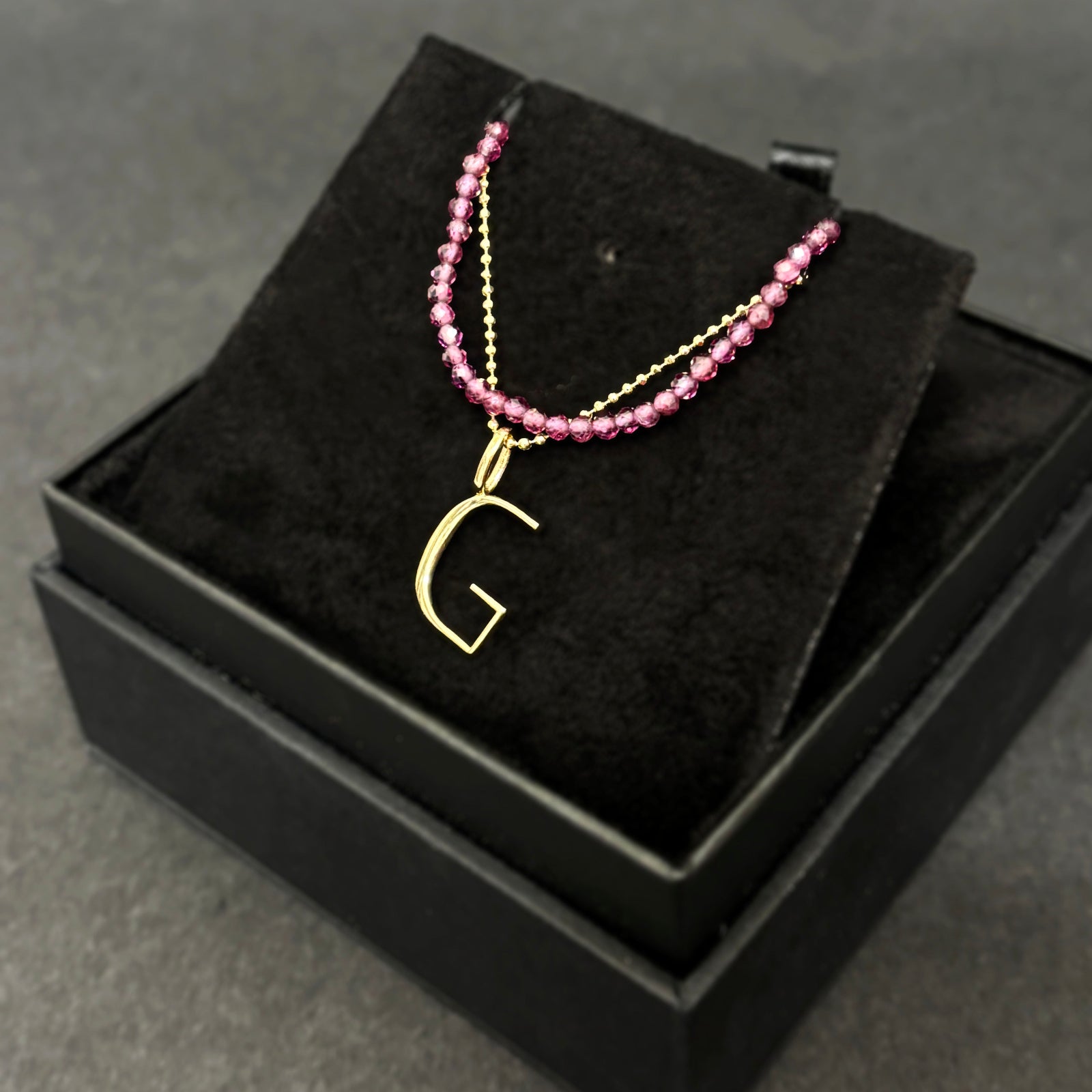 Purple garnet slim gemstone necklace with a diamond cut bead chain with letter G charm bundled in a black gift box.
