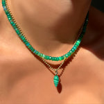 grass green faceted opal necklace with malachite drop charm on yellow gold bead chain on a model's neck.