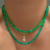 Green opal, faceted green opal, and green diopside slim gemstone necklace with amethyst knot charm on the neck.