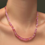 A single hibiscus sapphire necklace on a model's neck.