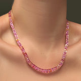 A single hibiscus sapphire necklace on a model's neck.
