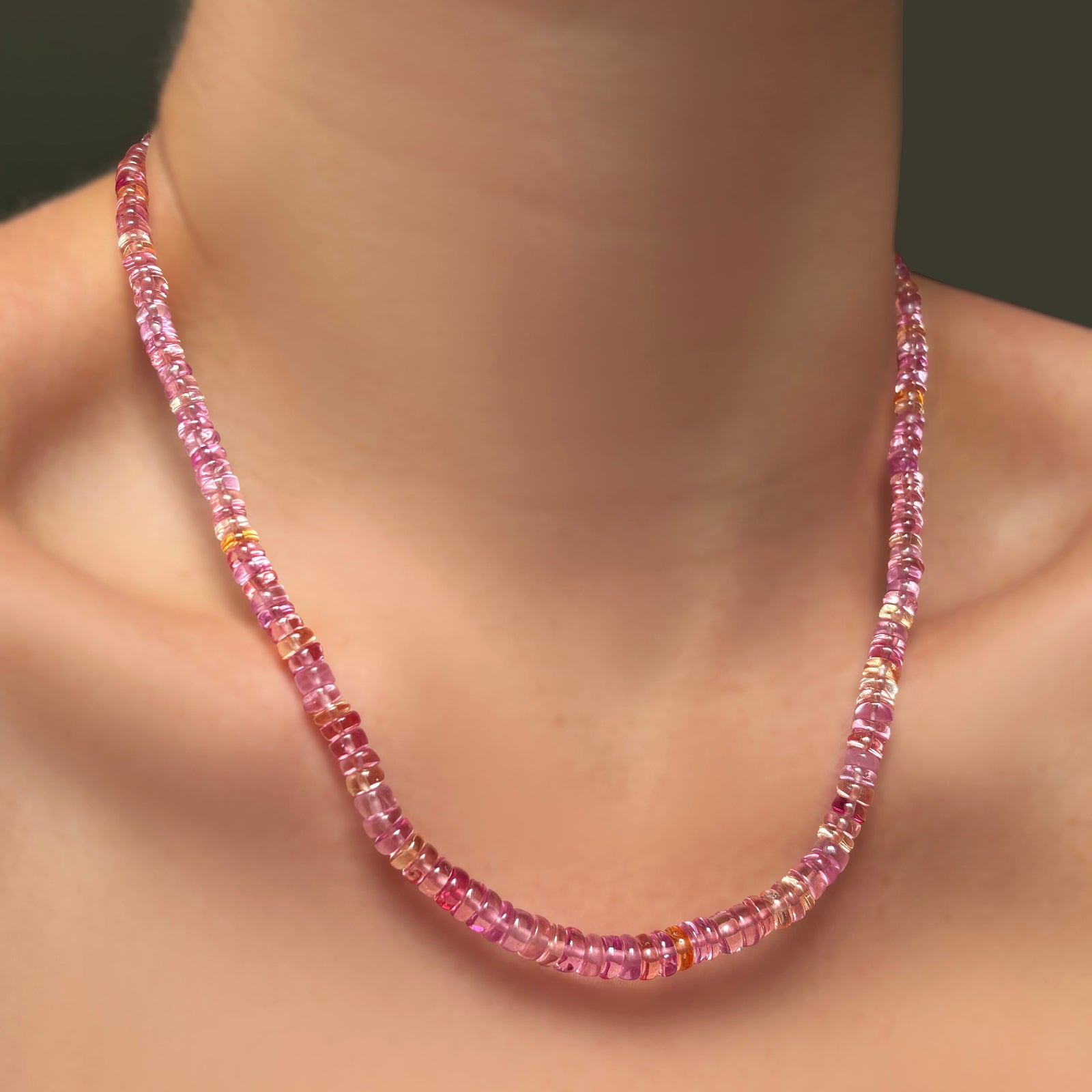 A single hibiscus sapphire necklace on a model's neck.