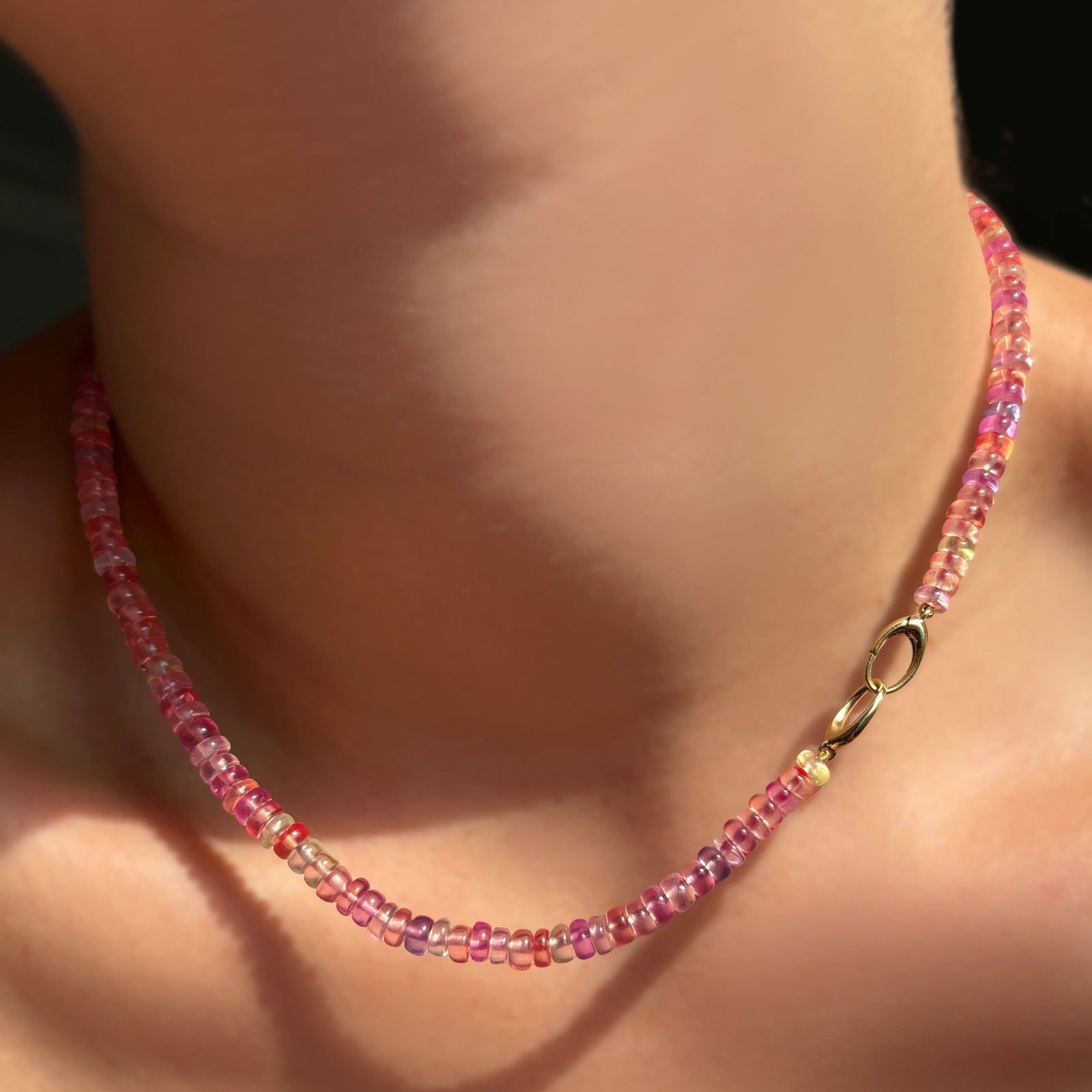 A hibiscus sapphire necklace with its 14k gold Evolution Clasp turned toward the front.