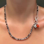 Faceted Rutilated Quartz Necklace with recycled sterling silver molten infinity charm lock holing a molten skull charm and carnelian drop charm with silver ripple bale on a model's neck.