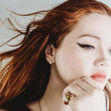 Molten knot ring with green tourmaline on a model with red hair, blowing in the wind.