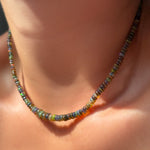 Labradorite grey opal necklace on the neck with sunlight.