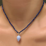 Lapis slim gemstone necklace with blue lace agate drop charm with ripple bale, layered on a model's neck.