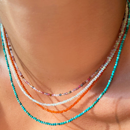 Four shimmering beaded necklace made of 2mm faceted opals in shades of milky white, orange, turquoise, and pinks on a gold linking lobster clasp.