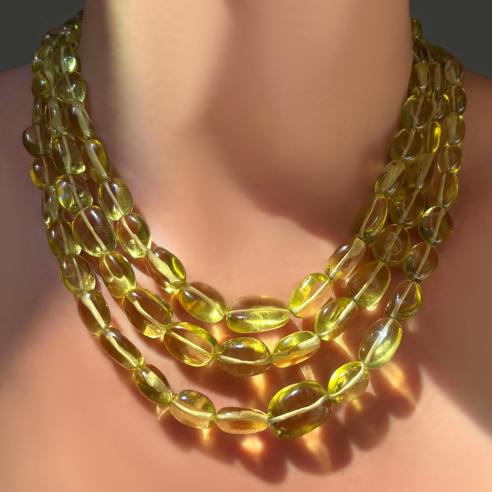 Three AMANDA PEARL Yellow Topaz Nugget Necklaces layered on a model's neck.
