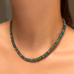 low light faceted opal necklace on the neck in sunshine.