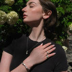 Model wearing sterling silver jewelry in front of a hydrangea bush in Brooklyn.