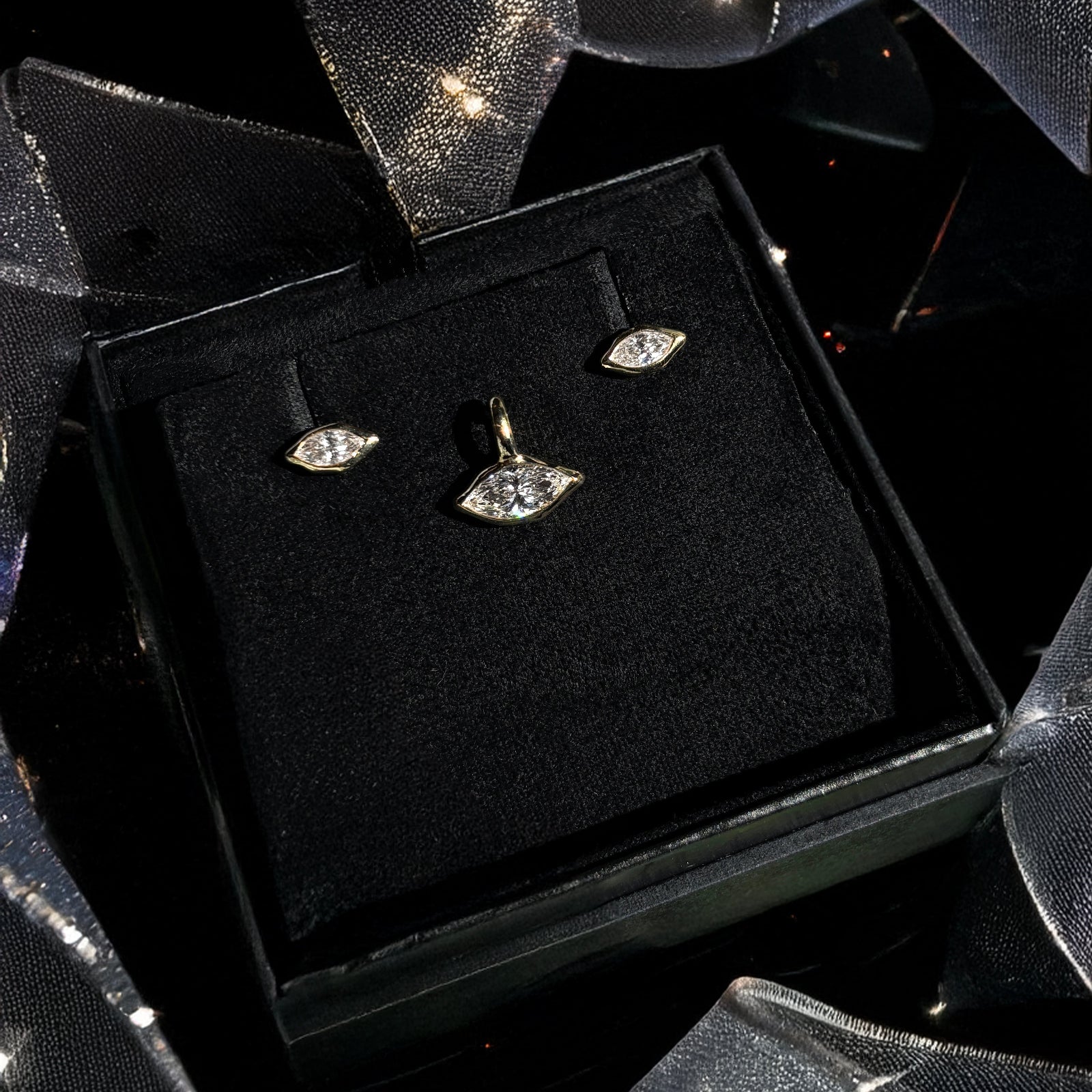 Marquise solitaire studs and charm boxed for a holiday gift with ribbons and holiday sparkle.