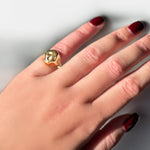 14k yellow gold molten skull pinky ring on a model's hand.