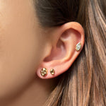 Molten skull stud with small molten stud and molten solitaire stud with marquise on a model's ear.