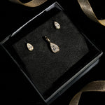 Molten solitaire charm and studs with pear cut diamonds boxed for a holiday gift with ribbon.