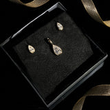 Molten solitaire charm and studs with pear cut diamonds boxed for a holiday gift with ribbon.