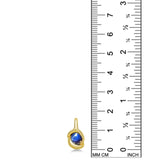 molten solitaire knot charm with star sapphire in yellow gold on a white background next to a ruler.