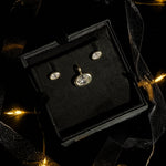 Molten Solitaire studs and charm boxed for a holiday gift with ribbons and holiday lights.