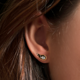 molten stud in yellow gold with diamond pavé on the ear of a person with long dark hair.