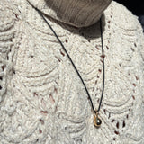 Molten Drop Charm on Quill Cording over a cream sweater.