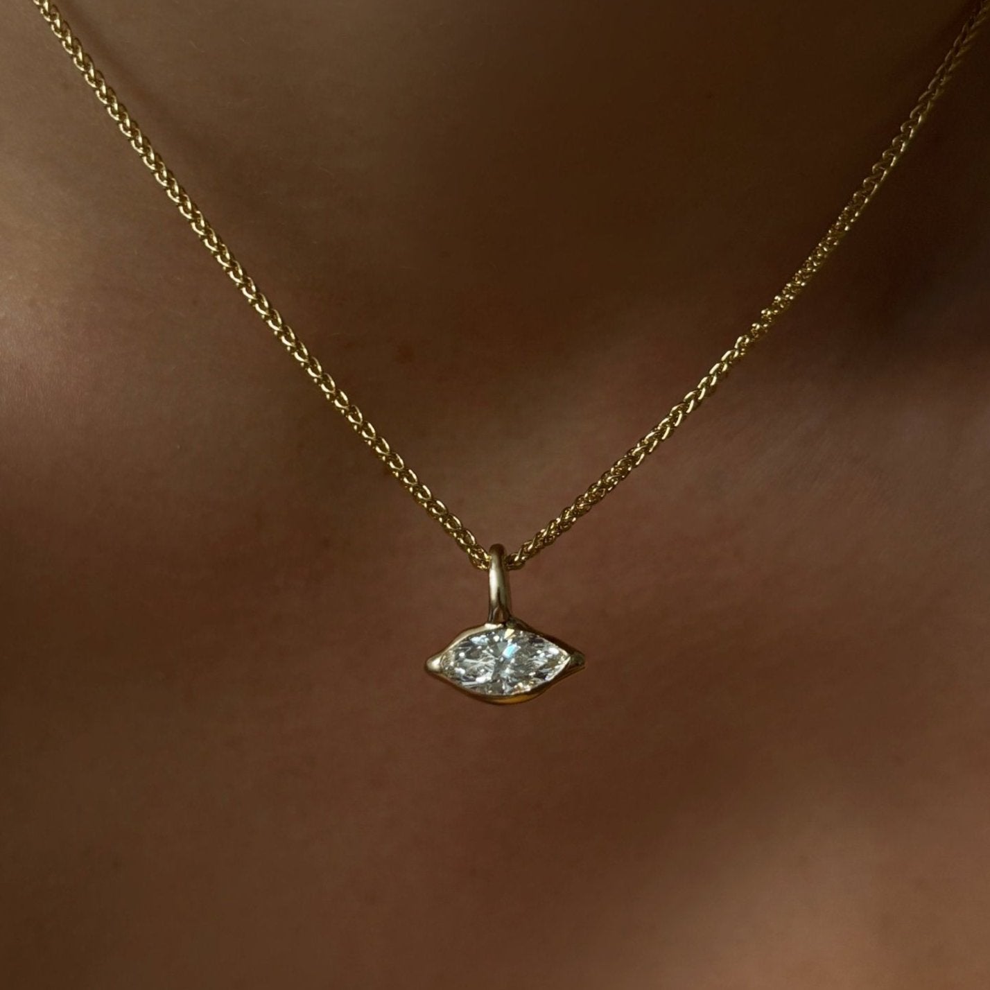 14K Recycled Gold Molten Solitaire Charm in Marquise layered on a gold wheat chain