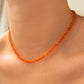 Shimmering beaded necklace made of smooth opal rondels in shades of orange on a slim gold lobster clasp. 
