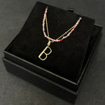Pink spinel slim gemstone necklace with diamond cut bead chain and letter B charm bundled in a black gift box.