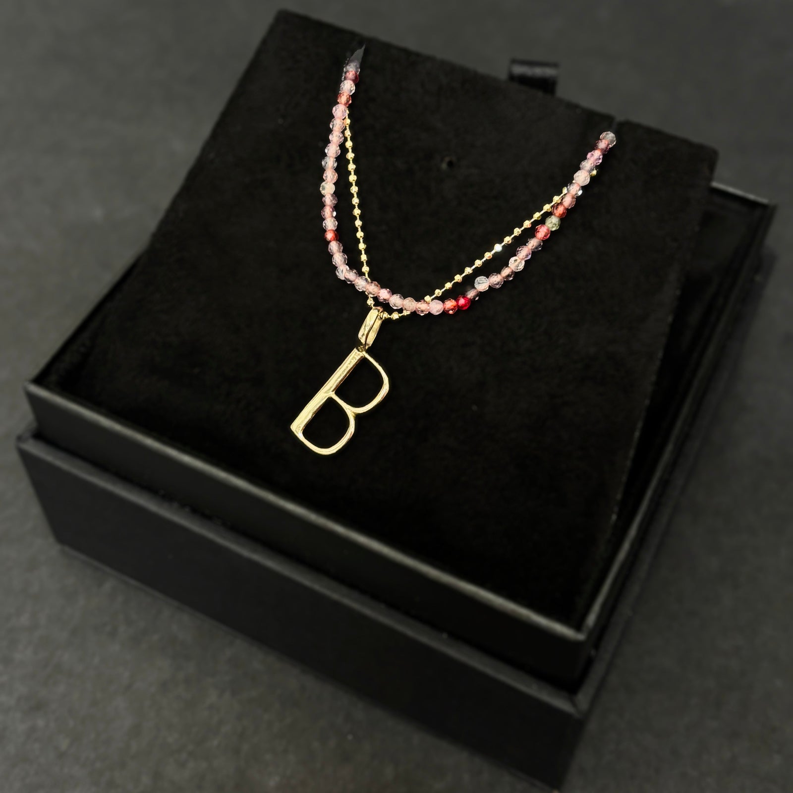 Pink spinel slim gemstone necklace with diamond cut bead chain and letter B charm bundled in a black gift box.