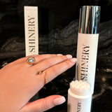Shinery skincare product with applicator and packaging on a dark background