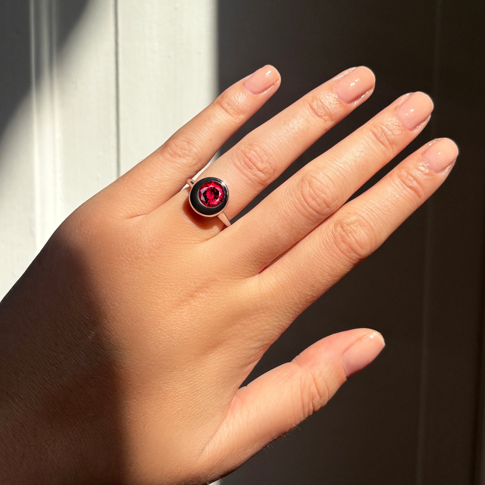 AMANDA PEARL Molten solitaire ring in recycled 14k gold with a cultivated ruby center stone on a model's hand.