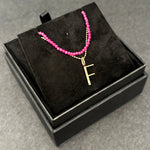 Ruby slim gemstone necklace with diamond cut bead chain with letter F charm bundled in a black jewelry box.
