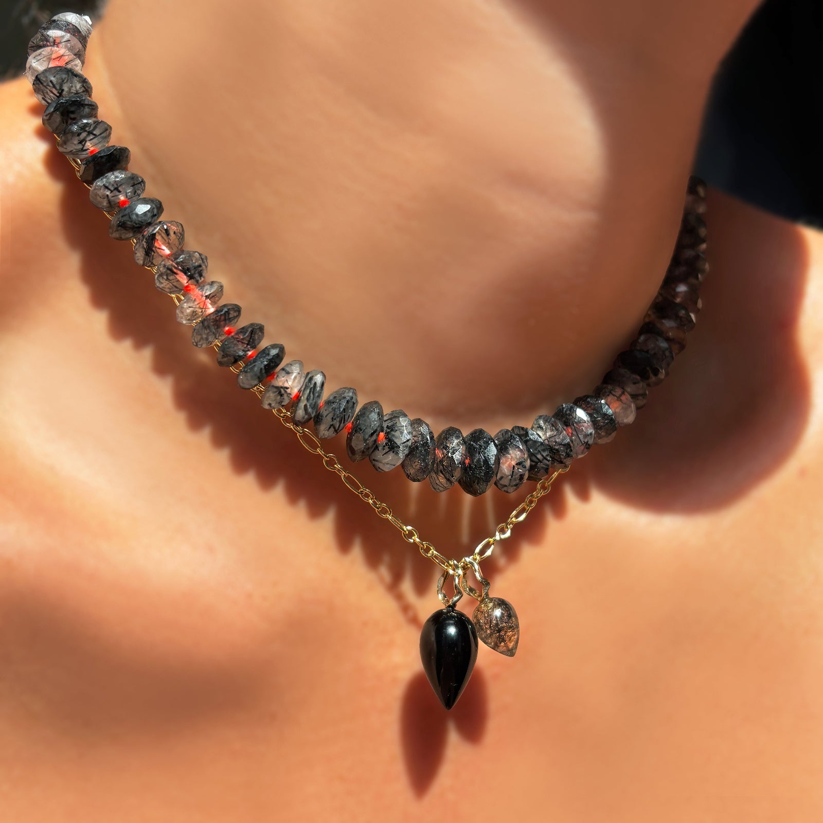 Rutilated Quartz on Neon collar layered over irregular link cable chain with Black Agate and Rutilated Quartz Drop Charms on a model's neck.